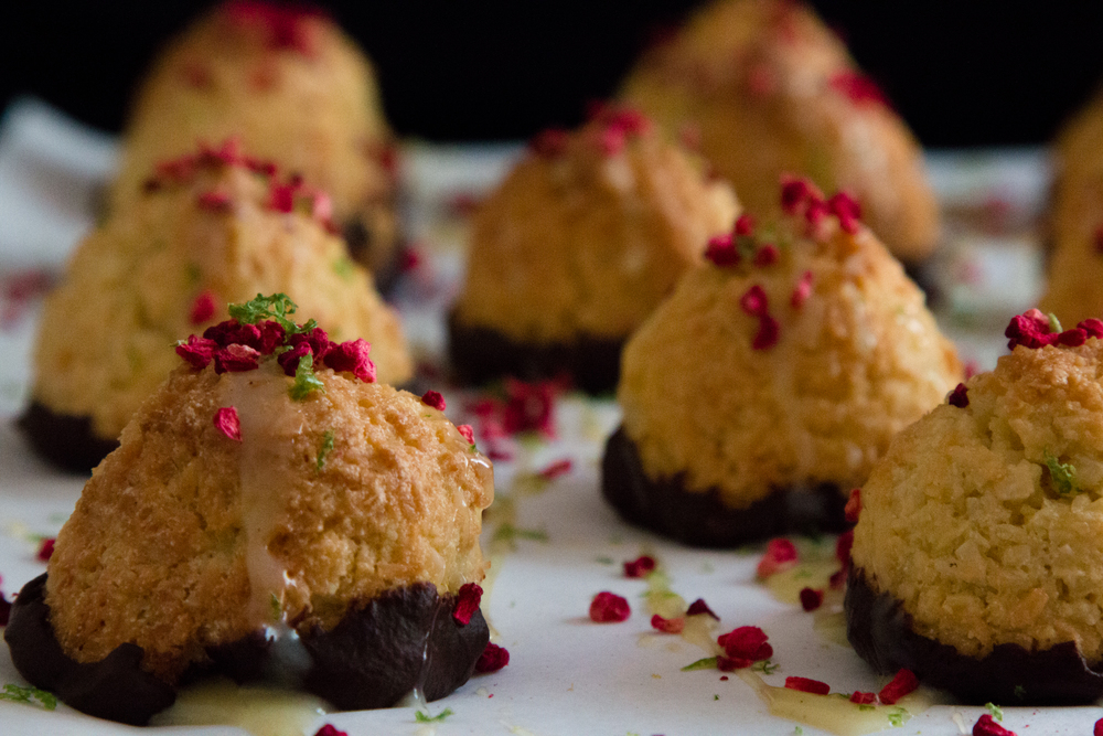 Macaroons on a tray dipped in Dark Chocolate and sprinkled with dried berries. 